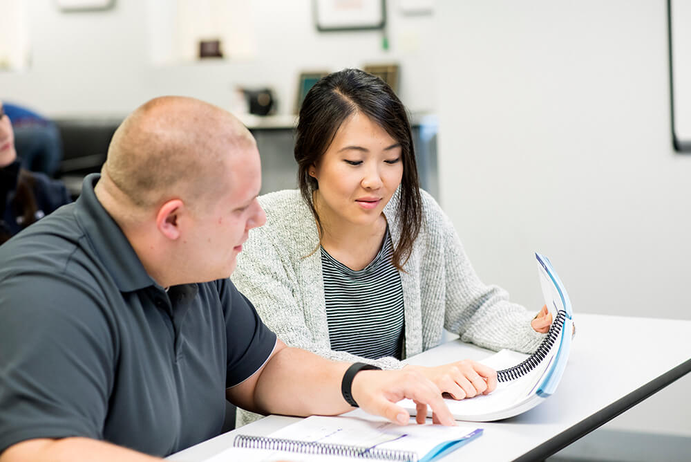 man and woman looking at booklet