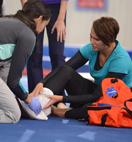 Heartsaver First Aid woman assisting another woman for twisted ankle image